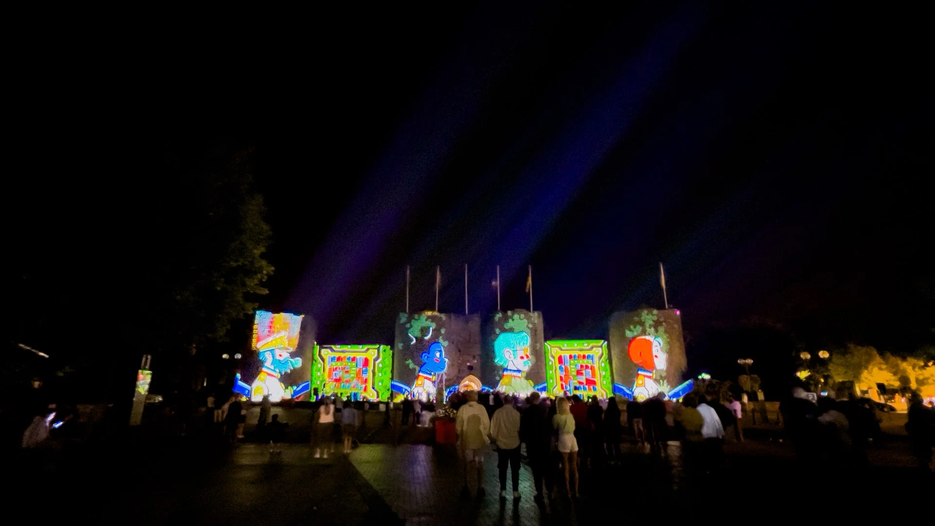 Photo prise lors du mapping, on peux y voir la façade avec la présentation des 4 personnages principaux et une foule de personne ermeveillé par la scène